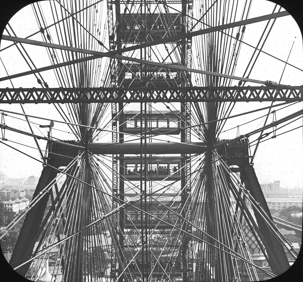 View through the support wires and passenger cars of the original Ferris Wheel