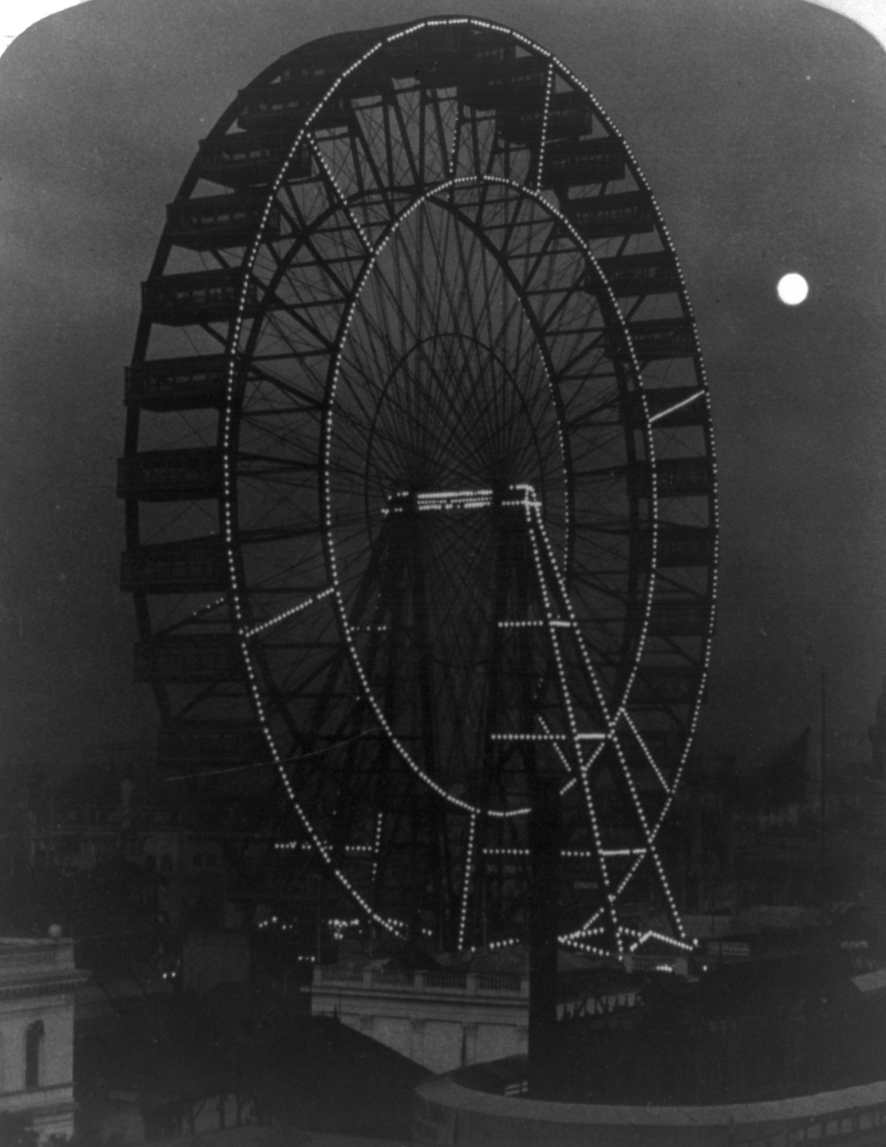 The original Ferris Wheel outlined by electric lights against the night sky at the 1893 exposition