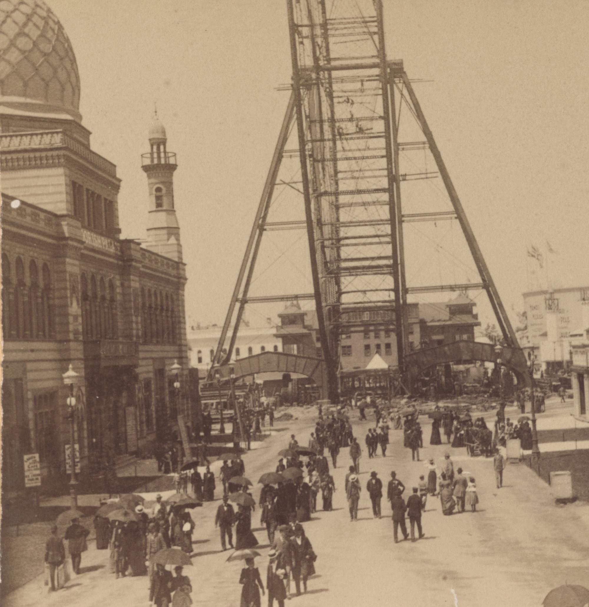 Visitors gathering on the Midway Plaisance beneath part of the original Ferris Wheel in 1893